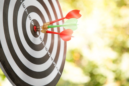 Close up shot of the dart arrow hit on bullseye, red dart arrow hitting in the target center of dartboard Target hit in the center, challenge in business marketing,Target and goal as concept.の写真素材