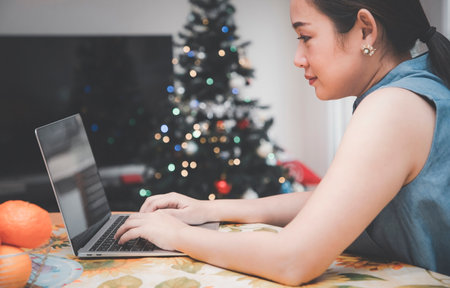 Working from home lifestyle young woman is business at home office, happy for working in the room, using portable computer empty screen mobile phone or laptop on the desk in the room conceptの写真素材