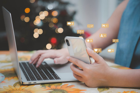 Woman hands using mobile smartphone and laptop with icon social media and marketing, person hands...