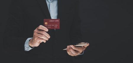 businessman is holding credit card and using laptop computer. Online shopping concept,banking and online shopping at the home.Close up.の写真素材