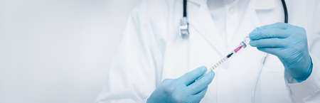 Doctor or scientist with a stethoscope holdingvaccine, measles, vaccine shot for diseases outbreak vaccination, vaccine Concept fight against virusの写真素材