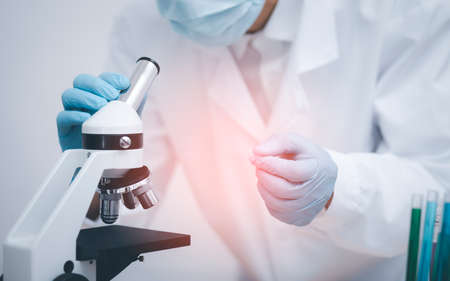 biochemical research scientist working with microscope for , laboratory glassware containing chemical liquid for design or decorate science, chemistry, biology, medicine and people conceptの写真素材