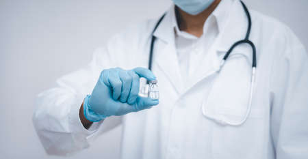 Doctor or scientist with a stethoscope holding  vaccine, measles, vaccine shot for diseases outbreak vaccination, vaccine Concept fight against virusの写真素材