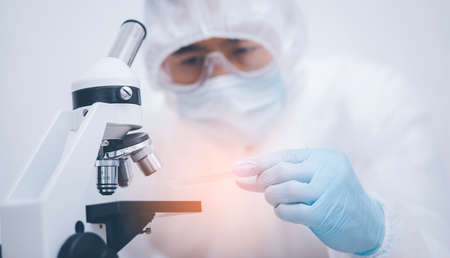 biochemical research scientist working with microscope for , laboratory glassware containing chemical liquid for design or decorate science, chemistry, biology, medicine and people conceptの写真素材