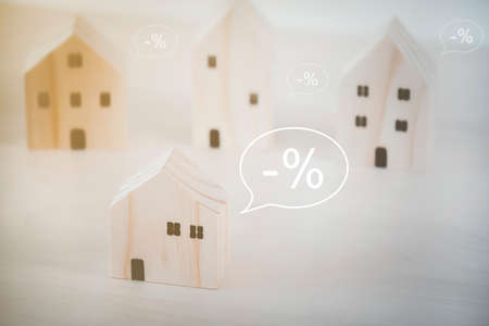 Insurer protecting a house with small House Model With textbox -% minus Percent, Planning to buy property. Choose what's the best. A symbol for construction ,ecology, loan concepts.の写真素材