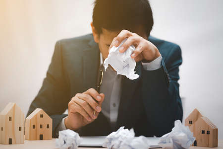 Work strain and spending planning concept, Businessman feeling sick and gripping paper crumpled, Business concept express anxiety or stress and Not ready to work, work at Homeの写真素材