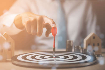Targeting the business concept, Businessman touch red arrow dart to virtual target dart board,Executive marketing, investment goal and target for business investment concept, mini home and Coins stackの写真素材