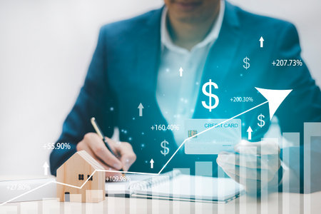 Businessman holding credit card and market graph on the Internet on the laptop computer with credit card, online payment, shopping online, e-commerce, internet banking, spending money concept.の写真素材