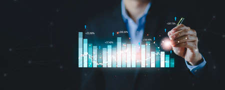 Businessman use pen touch line graph of business stock market concept, analytics and financial, Changes in new planning, Business growth, ideas and perspectives, Stock investment, and dividendsの写真素材