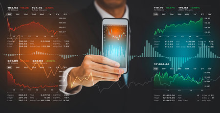 Businessman hold smartphone and Stock market or forex trading graph and candlestick chart suitable...