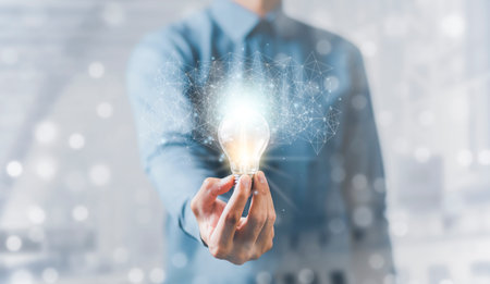 Businessman hand holding light bulb with line connect and working on the desk, Creativity and...