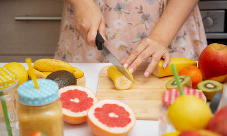 Happy woman enjoy preparing freshly squeezed fruits with vegetables for making smoothies for breakfast together in the kitchen.diet and Health concept.の写真素材