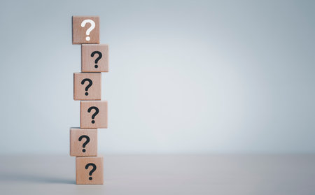 Hand hold Wooden cube block in question mark mean what on cement table background, column of wooden blocks with question sign mark. copy space,FAQ frequently asked questions, Answer, Informationの写真素材