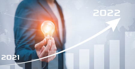 Business holding light bulb with growth data chart arrow with diagram 2022 budget, Businessman...