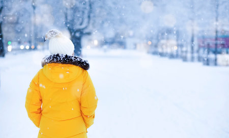 Asian Young woman alone slowly walking on snow covered boardwalk after snowfall. Enjoying fresh air...