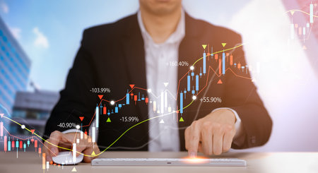 Businessman interacting with laptops, phones, and tablets with featuring stock tickers or graphs,...