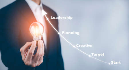 Businessman holding light bulbs, ideas of new ideas with innovative technology and creativity, concept creativity with bulbs that shine glitter, businessman holding illuminated light bulb, innovationの写真素材