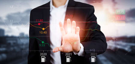 Oil energy graph of the world market, impact on the economy concept,Businessman touch chart with the indicator on the oil price slide at gas station, fluctuations in oil prices and exchange trade.の写真素材