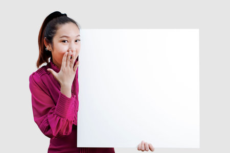 Business Cheerful Young Asian holding a large white sign. Isolated portrait, Blank empty paper in...