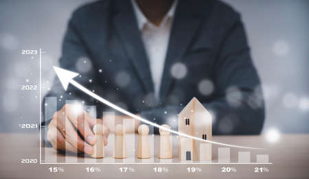 Man hand choosing mini wood house model from the model on wood table, Planning buy Real Estate, Planning and property, Planning Buy Real Estate, Planning to buy property. Home insurance and security.の写真素材