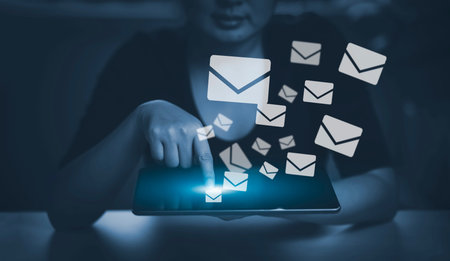 woman holding smartphone with communication icons, letter icon, email icons, and newsletter email...