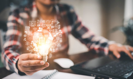 Woman hand hold light bulb with icons work on the desk, Creativity and innovation are keys success....