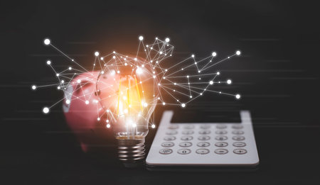 Thinking and creative concept, calculator with piggy bank and light bulb style bokeh vintage dark background,Concept The idea of reading books, knowledge, and searching for new ideas.の写真素材
