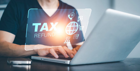 Hand using tablet with bar  TAX REFUND and refund tax of duty taxation business, graphs and chart being demonstrated on the screen media,  tablet pc and selecting tax refund.の写真素材