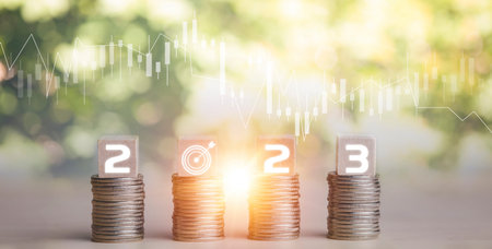 Coins stack and number 2023 on square wood and icon on nature background, Money spending planning,...