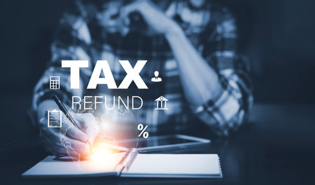 Hand using tablet with bar  TAX REFUND and refund tax of duty taxation business, graphs and chart being demonstrated on the screen media,  tablet pc and selecting tax refund.の写真素材