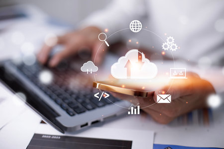 Businessman hand holding smartphone and laptop with cloud computing diagram show on hand. Cloud...