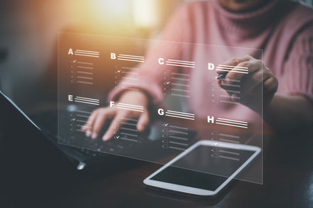 Businessman using a laptop and Taking an assessment, questionnaire, evaluation, online survey online exam Choosing the right answer in exam by filling out the online survey form,Answer  test questionsの写真素材