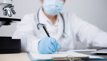 Female Doctor sitting at desk and writing a prescription her patient, Prescription or signing medical report or medical certificate or health check-up form documents in offices or clinics or hospitalsの写真素材