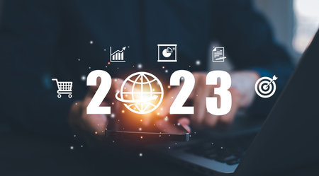 Businessman holds tablets with target and number new year 2023 on the business graph background,...