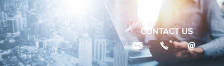 Communication and Contact us or Customer support hotline people connect. Hand using a laptop and touching on virtual screen contact icons, email and address, live chat with internet wifi.の写真素材