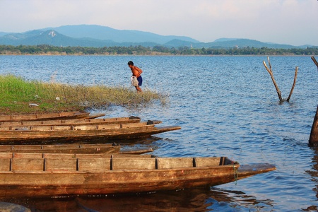 fisherman and row boat in lakeの写真素材