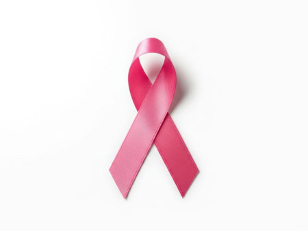 This image features a single pink ribbon, symbolizing breast cancer awareness, isolated on a white background. The ribbon is prominently displayed in the center of the image, making it the focal point. The white background enhances the visibility and emphasis of the pink ribbon.の素材