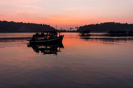 Boat passing at the bay of Bang Bao in the evening on Koh Chang in Thailand.