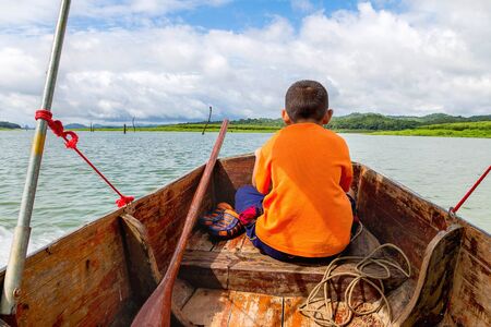 Children sitting on the bow, he was an assistant boat driver.の写真素材