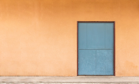 Green door and orange wall, used for background image.の写真素材
