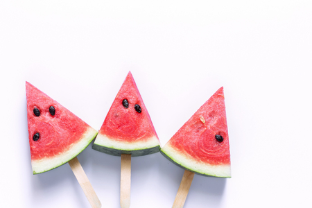 Watermelon sliced into a slice of wood on an white background.の写真素材