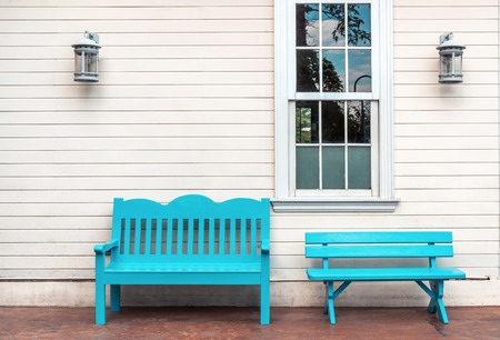 Two Light blue wooden bench and a window on a White wall.の写真素材