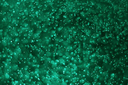 green bokeh.Bokeh of water with black background, tinted green  for backgroundの写真素材