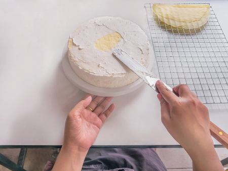 Chef making crepes cake by Stack and painted with whipped cream on top.の写真素材