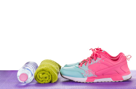 Women's Sports Shoes, Water Bottles, Towels on a fitness pad ,isoalted on white ackgroundの写真素材