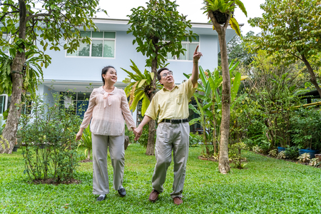 Asian elderly couples are walking inside the backyard to see nature.の写真素材