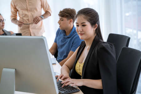 A beautiful young businessman is using a computer to work within the office.の写真素材