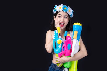 Portrait Beautiful asian woman Take Plastic gun on black background.  water gun party or Songkran festival, Thailand. Thai New Year's Dayの写真素材