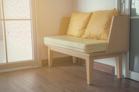 The interior of the house has a sofa with cushions for sitting.の写真素材