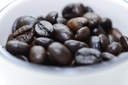 coffee bean in white cup and oak wood plate